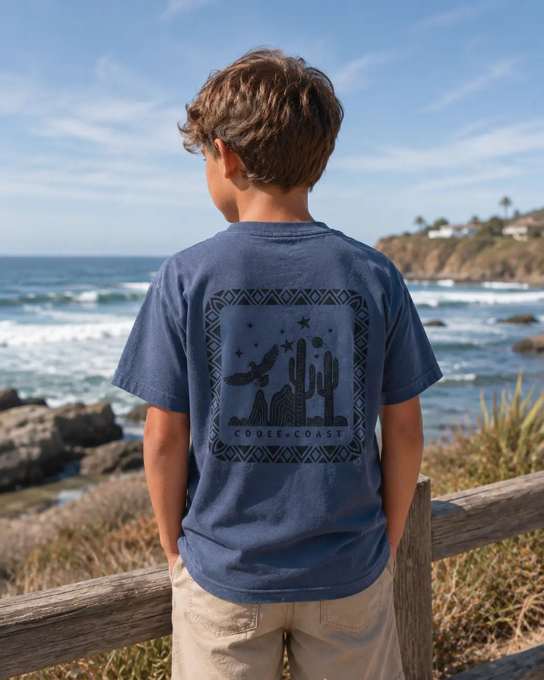 Back view of boy wearing Cooee Coast, coastal flow tee desert sea featuring back print eagle.