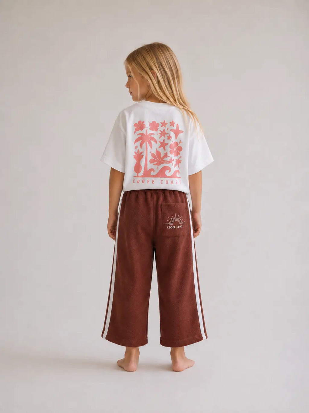back view of girl wearing Cooee Coast chocolate retro terry pants featuring embroidered back pocket, relaxed fit.