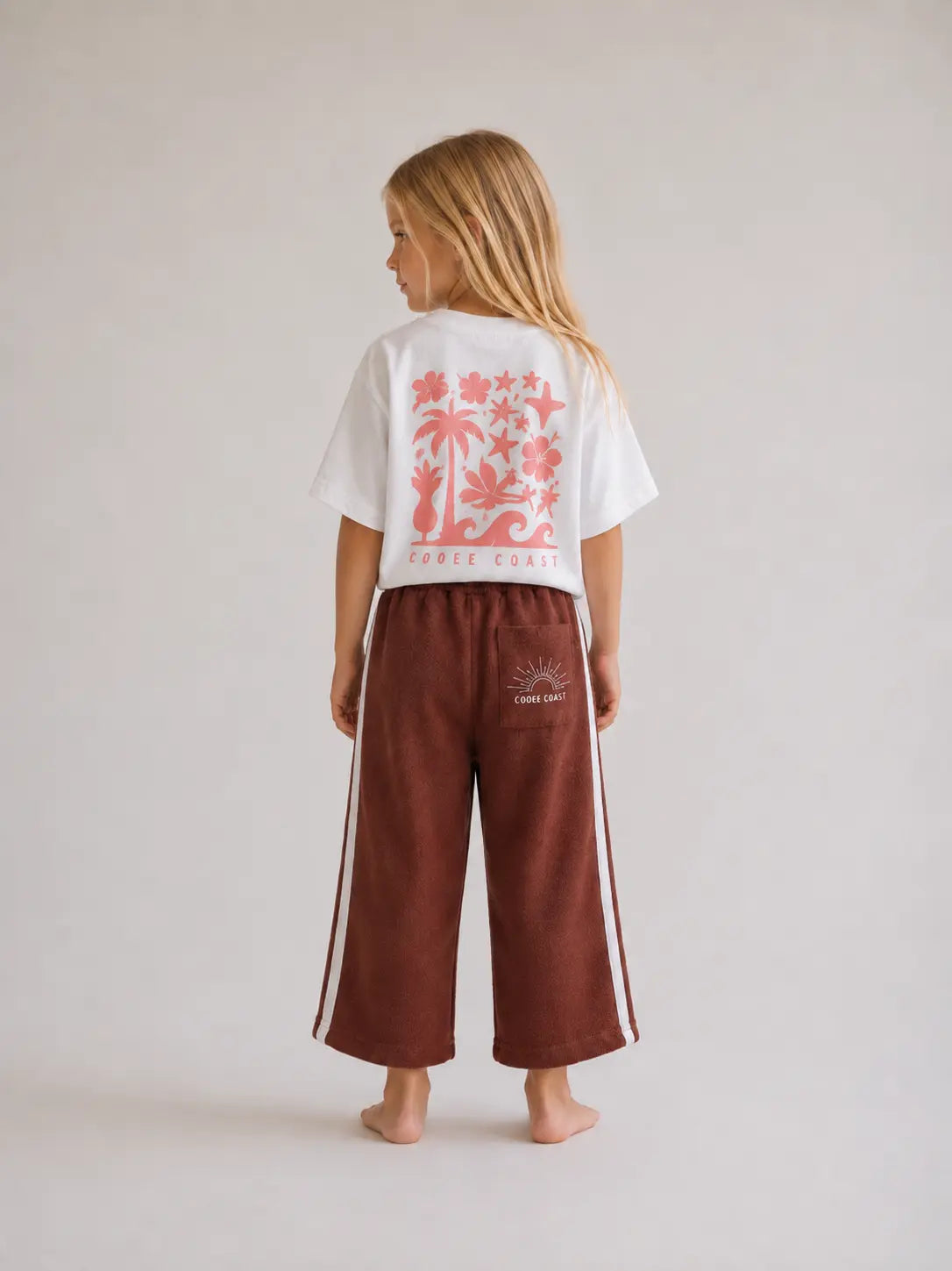 back view of girl wearing Cooee Coast chocolate retro terry pants featuring embroidered back pocket, relaxed fit.