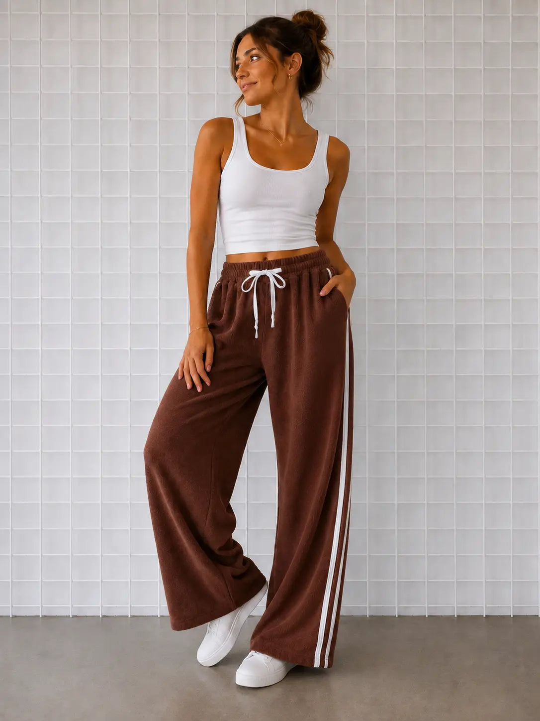 Woman wearing Cooee Coast Chocolate terry pants featuring embroidered back pocket, relaxed fit.