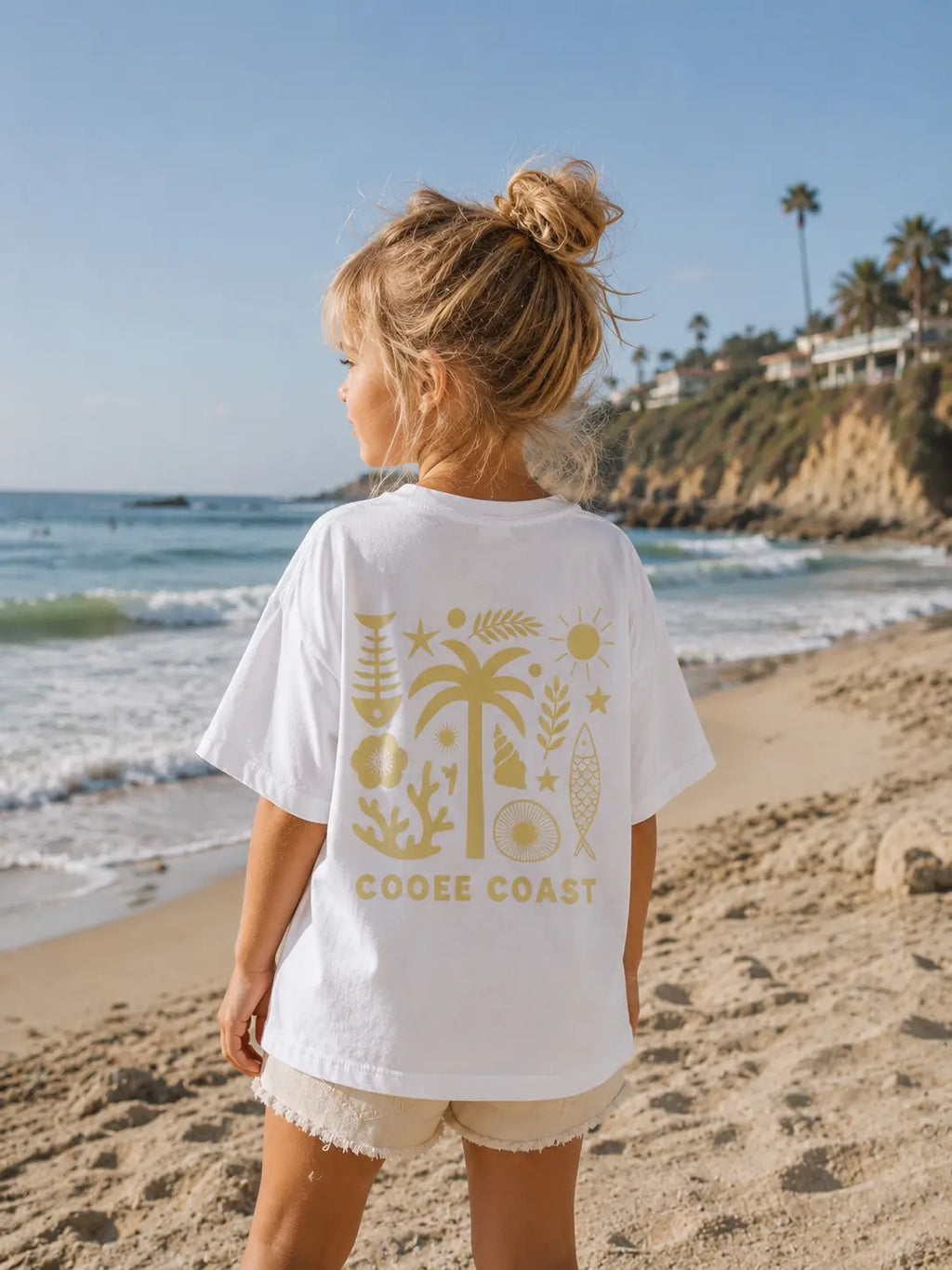 Back view of girl wearing Cooee Coast, coastal flow tee featuring lemon palm back print
