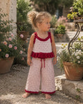 Girl wearing Cooee Coast Mon Chéri two-piece knit set featuring textured blush fabric and cherry red tri