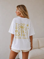 Back view of woman wearing Cooee Coast, coastal flow tee featuring lemon palm back print