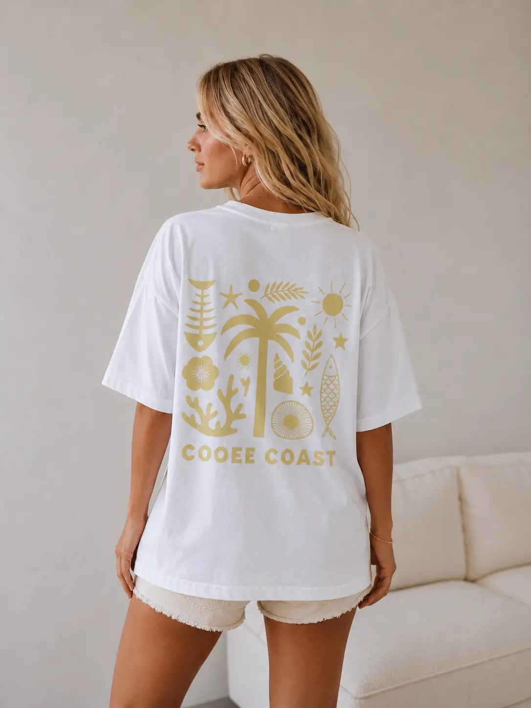 Back view of woman wearing Cooee Coast, coastal flow tee featuring lemon palm back print