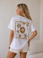 Back view of woman wearing Cooee Coast, coastal flow tee featuring sun back print