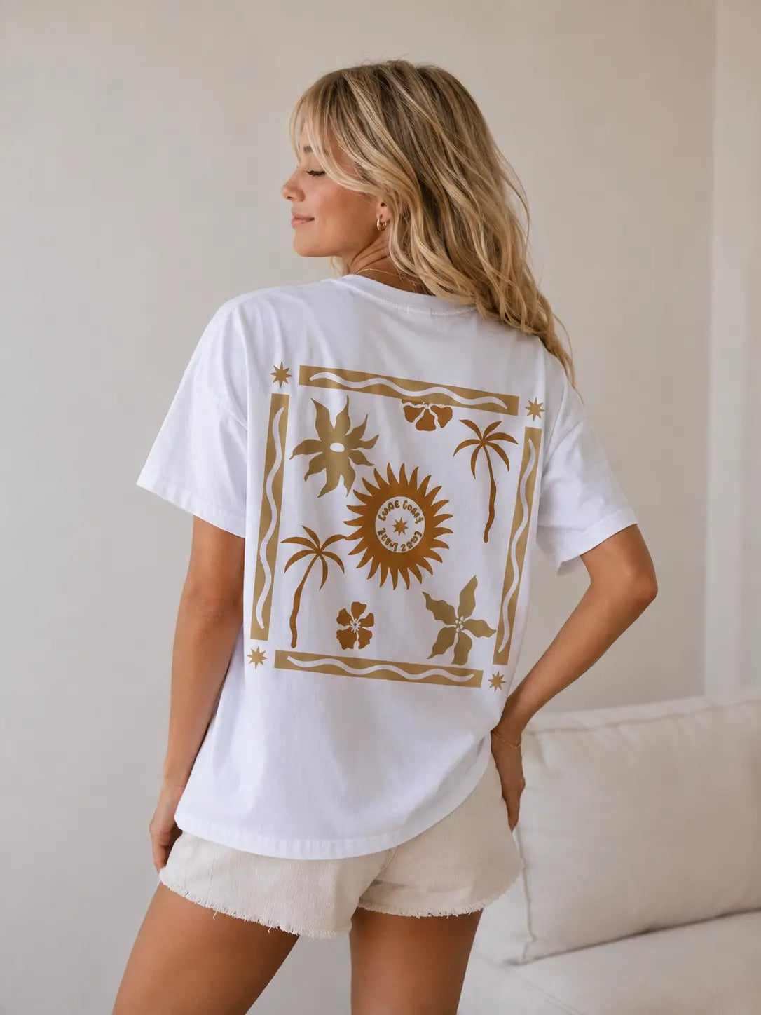 Back view of woman wearing Cooee Coast, coastal flow tee featuring sun back print