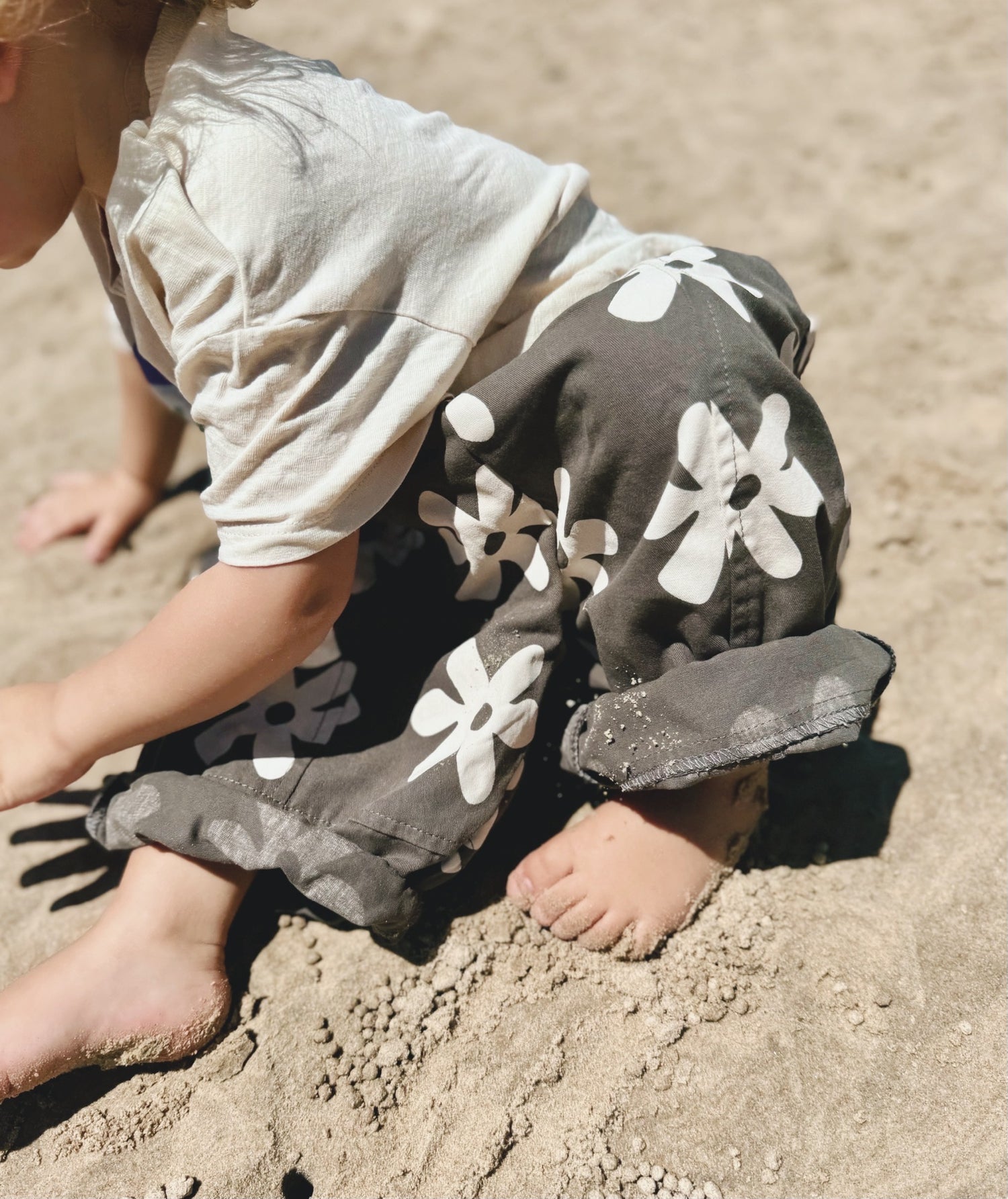 Toddler playing in sand with floral Lenny Pants