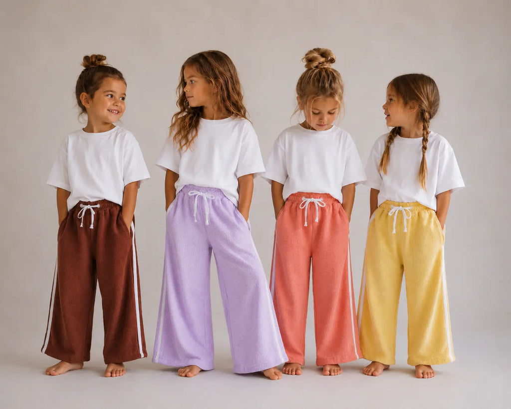 Four girls wearing Cooee Coast retro terry pants featuring embroidered back pocket, relaxed fit.