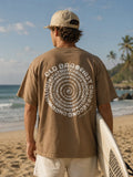 Man holding surfboard wearing Cooee Coast Men’s Tee in relaxed fit with soft premium cotton