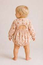 Back view of baby wearing Cooee Coast Willow Romper featuring open back and wooden button detail