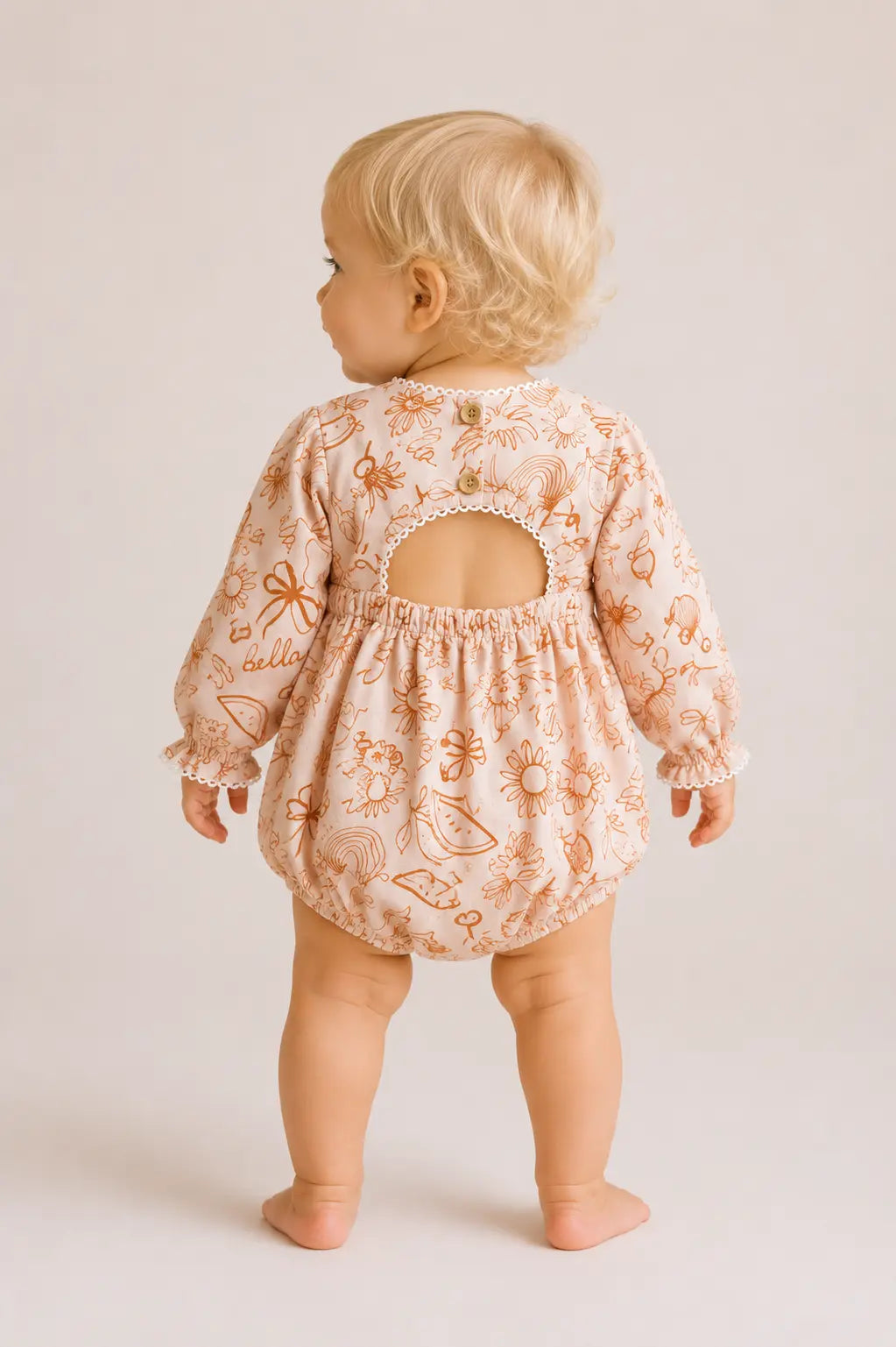 Back view of baby wearing Cooee Coast Willow Romper featuring open back and wooden button detail